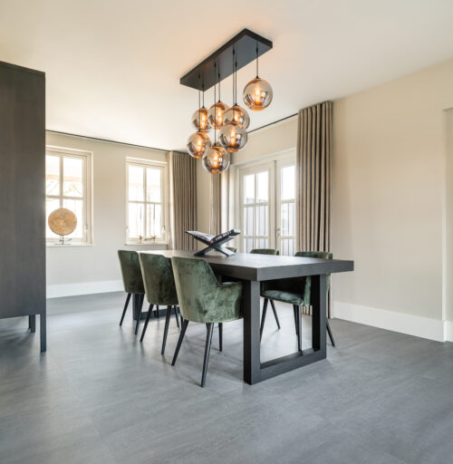 Groene eetkamerstoelen op een pvc betonlook vloer