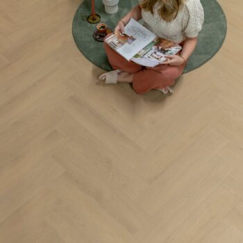 pvc mystiq 1902 visgraat vrouw leest boek op een stoel