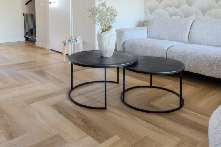 private label pvc vloer gelegd in elleboogpatroon woonkamer hoekbank salontafelset