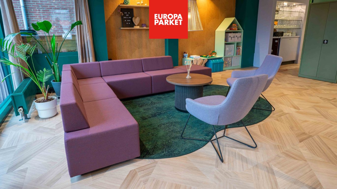 Centrale buurtcentrum Ontmoetingsruimte zit gedeelte paarse hoekbank en stoelen